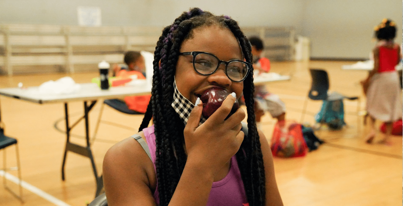 Food Distribution in Schools Girl Eating Apple COVID News