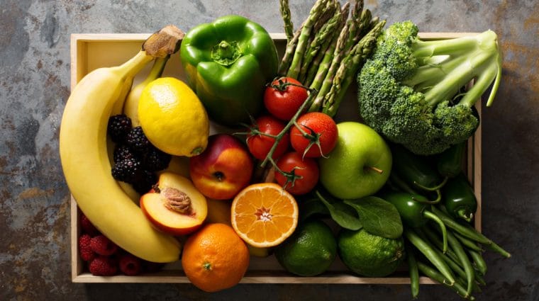 Fresh and colorful vegetables and fruits in a wooden crate