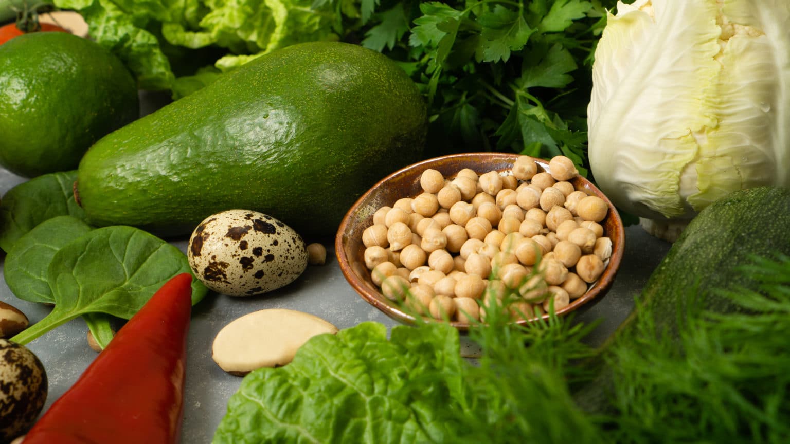 Fresh healthy vegetables with avocado, chickpeas, nuts and herbs for a healthy diet. A balanced diet with fiber and vegetable proteins